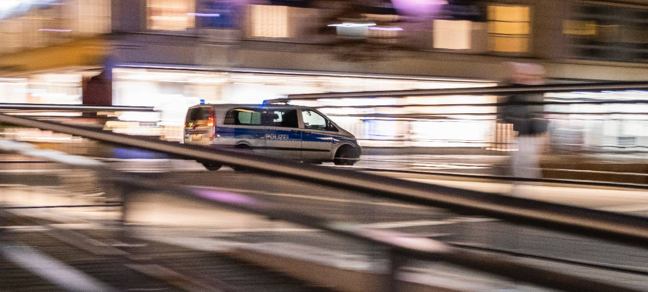 Ein Polizeiauto fährt nachts schnell durch die Stadt.
