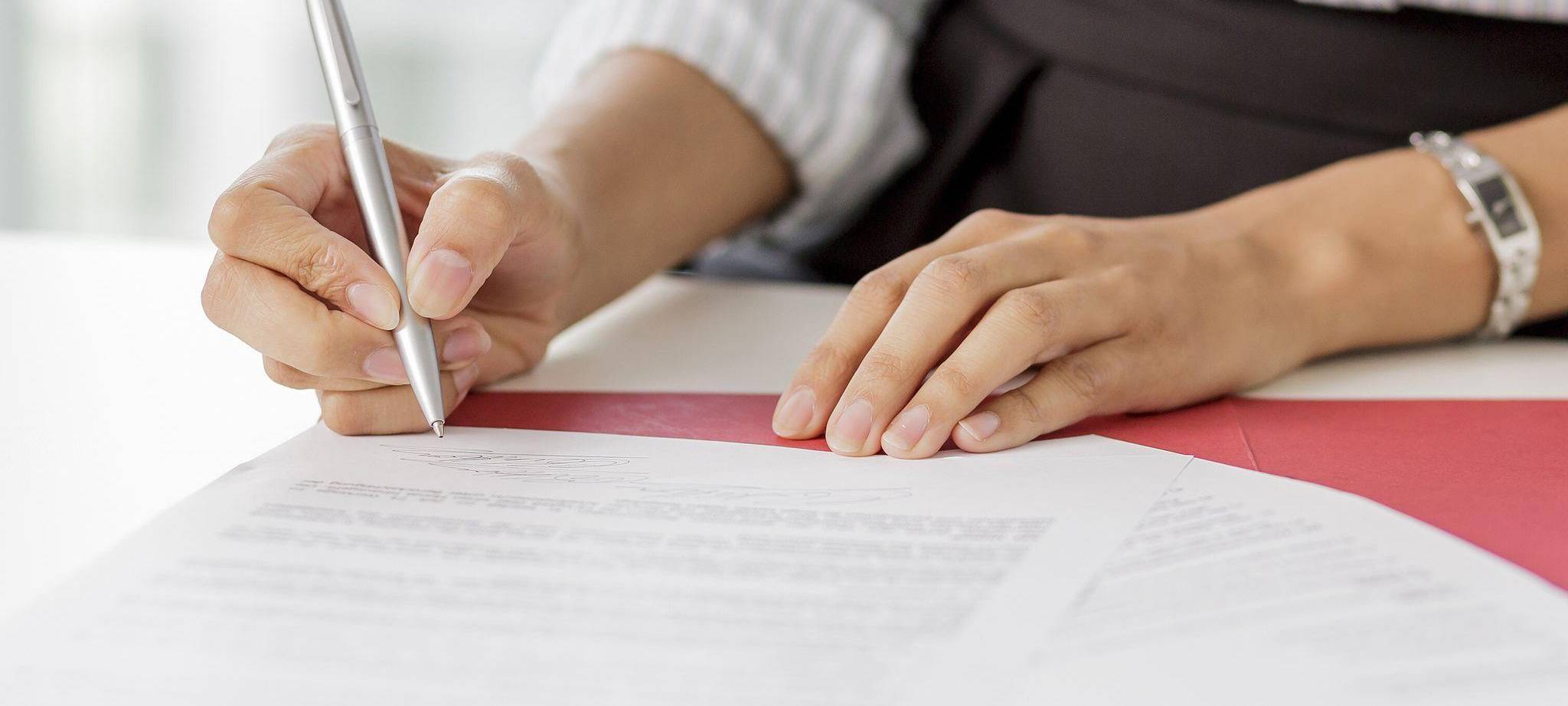 Frau unterschreibt ein Arbeitszeugnis