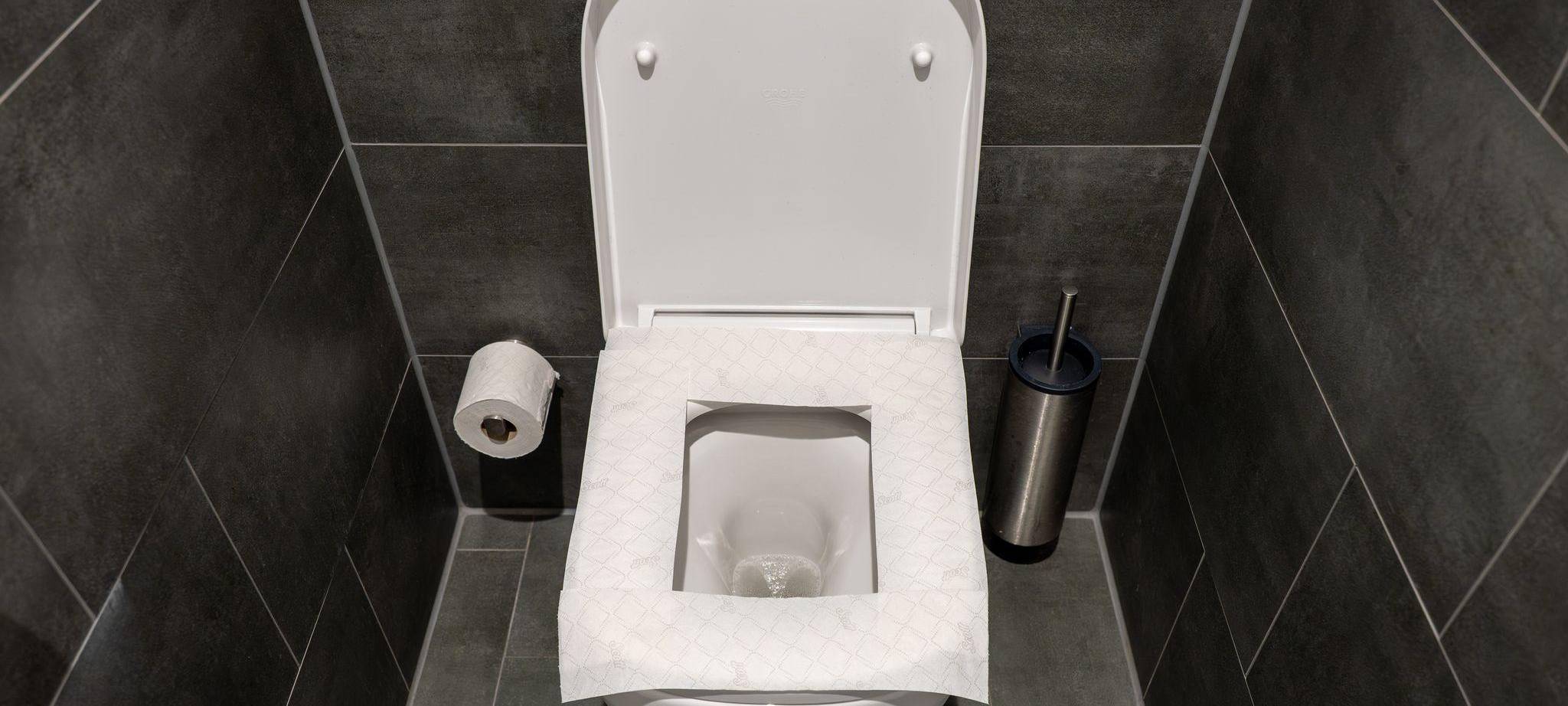 Ein Toilettensitz ist mit Toilettenpapier belegt