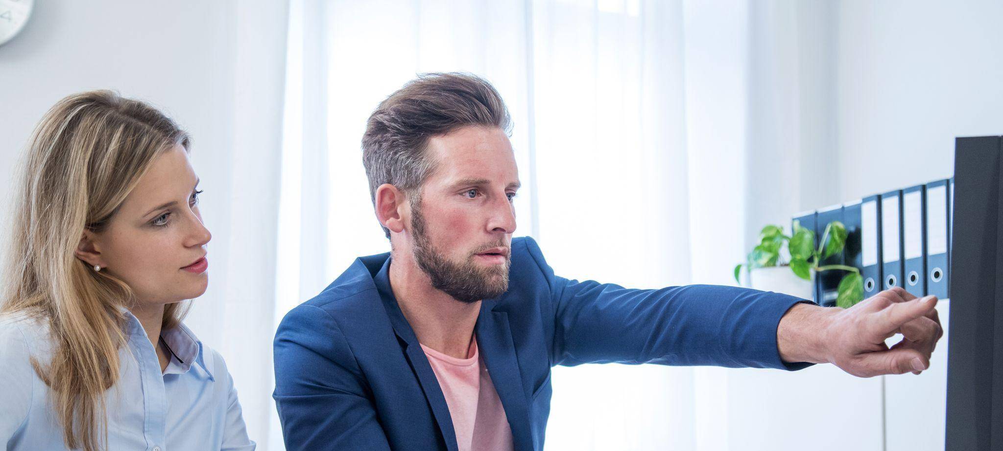 Kollegen blicken auf einen Monitor