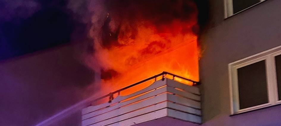 Flammen schlagen aus der Wohnung in dem Mehrfamilienhaus in Recklinghausen-Hochlarmark.