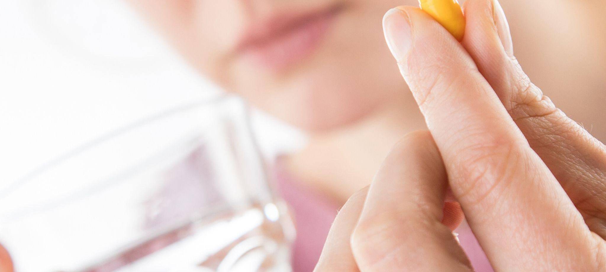 Frau hält eine Tablette in der Hand