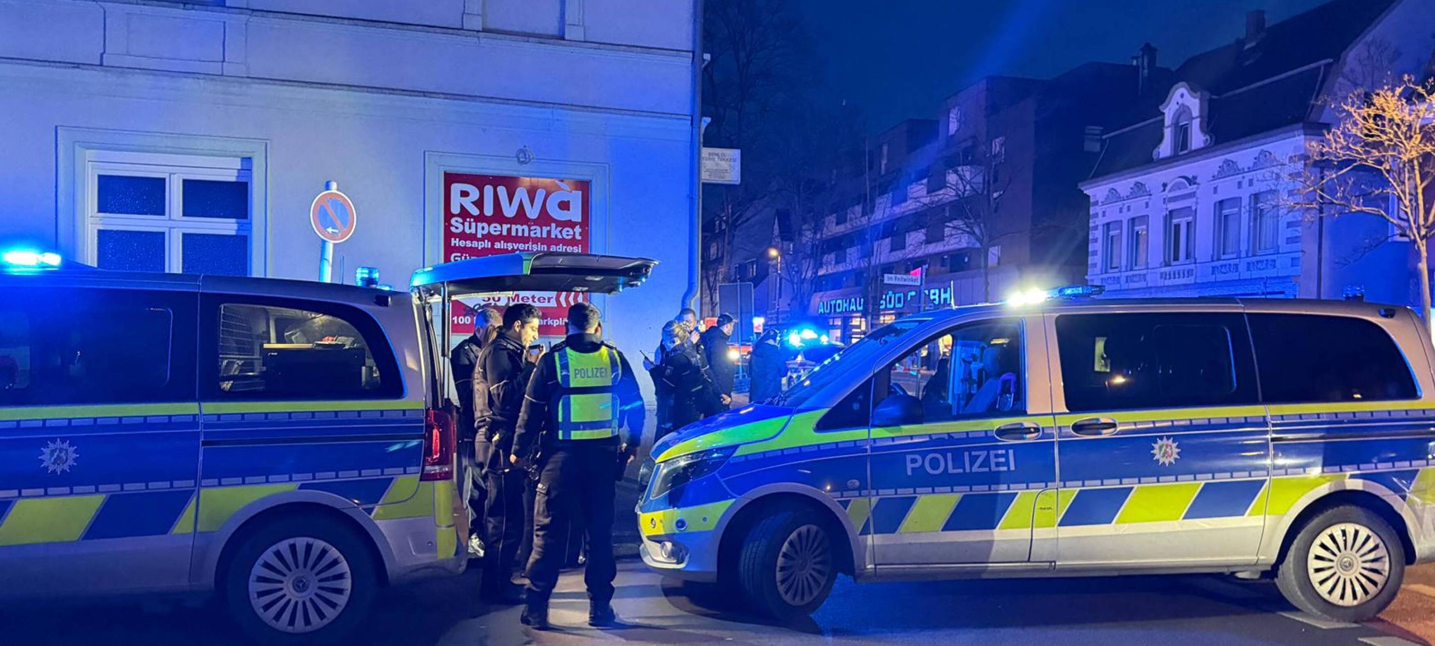 Zwei Polizeiwagen und mehrere Polizisten stehen vor dem abgesperrten Tatort in Recklinghausen