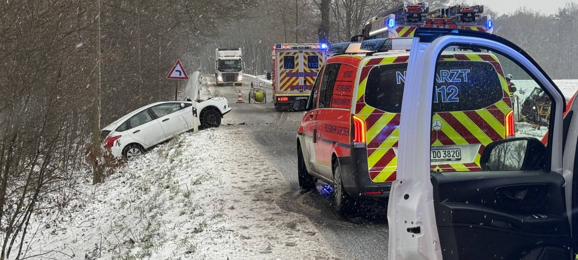 Ein weißes Auto, das im Straßengraben der B224 liegt, sowie ein Rettungswagen davor