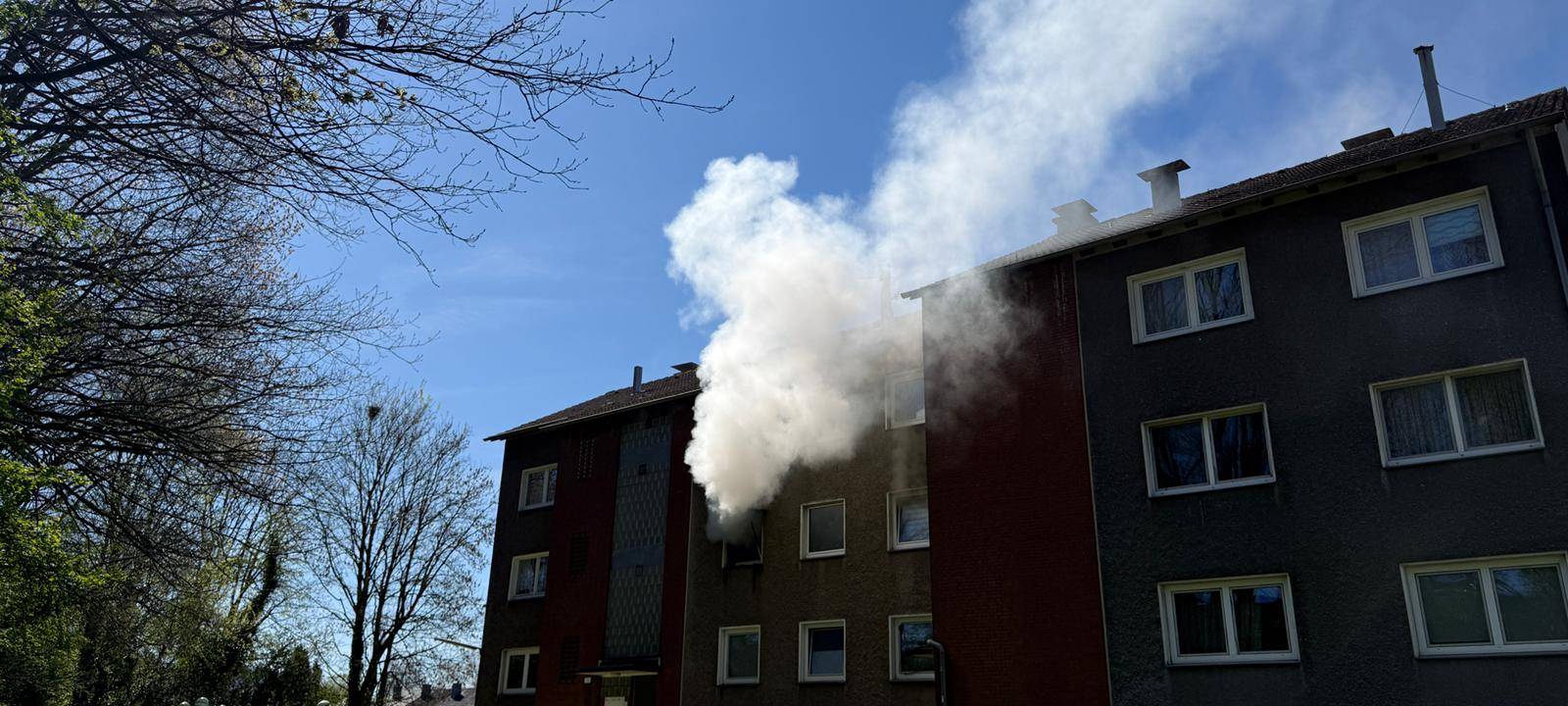 Weißer Rauch quillt aus einer Wohnung eines Mehrfamilienhauses in Recklinghausen