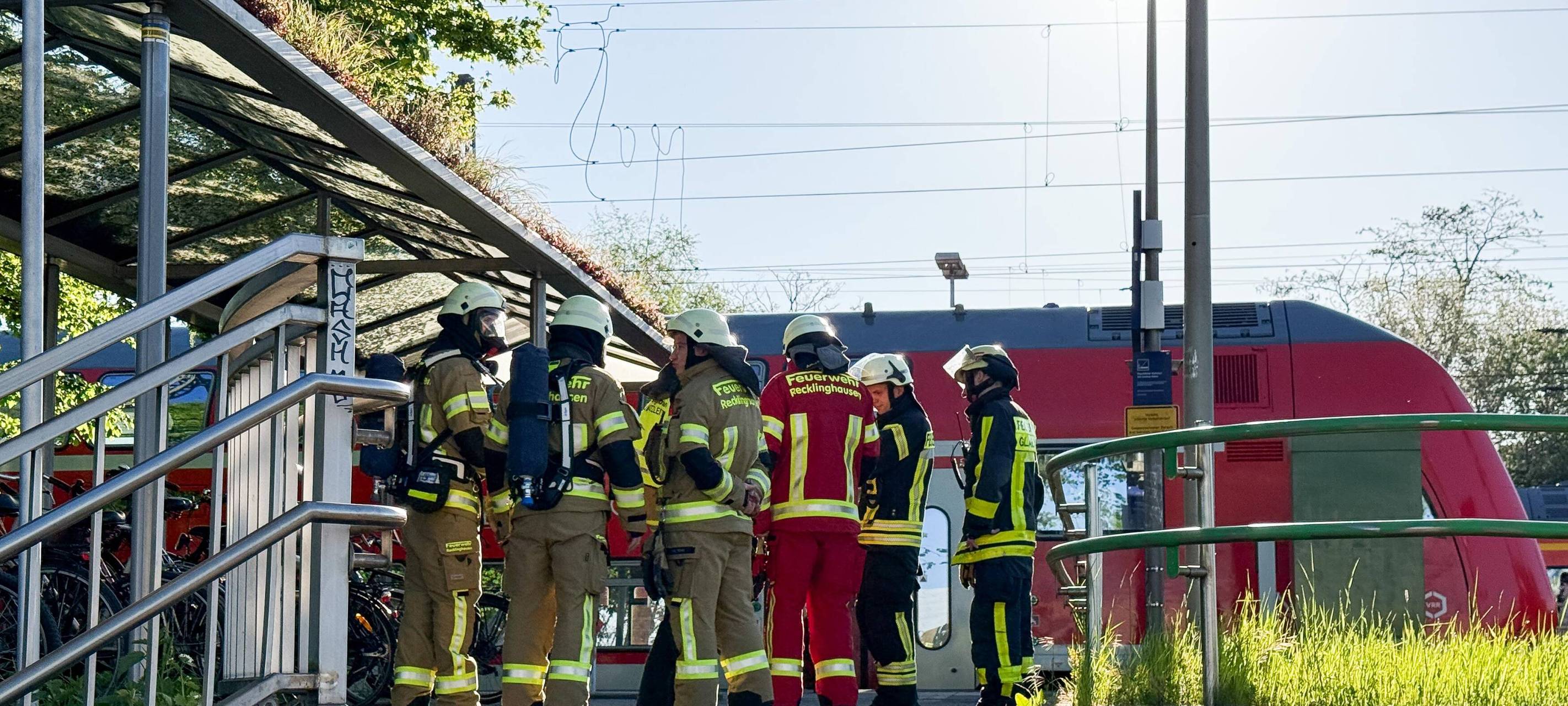 Feuerwehrleute stehen am Bahnhof Recklinghausen-Süd vor einem liegen gebliebenen Zug