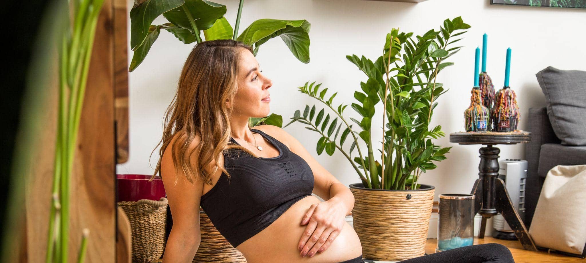 Eine schwangere Frau berührt ihren Babybauch