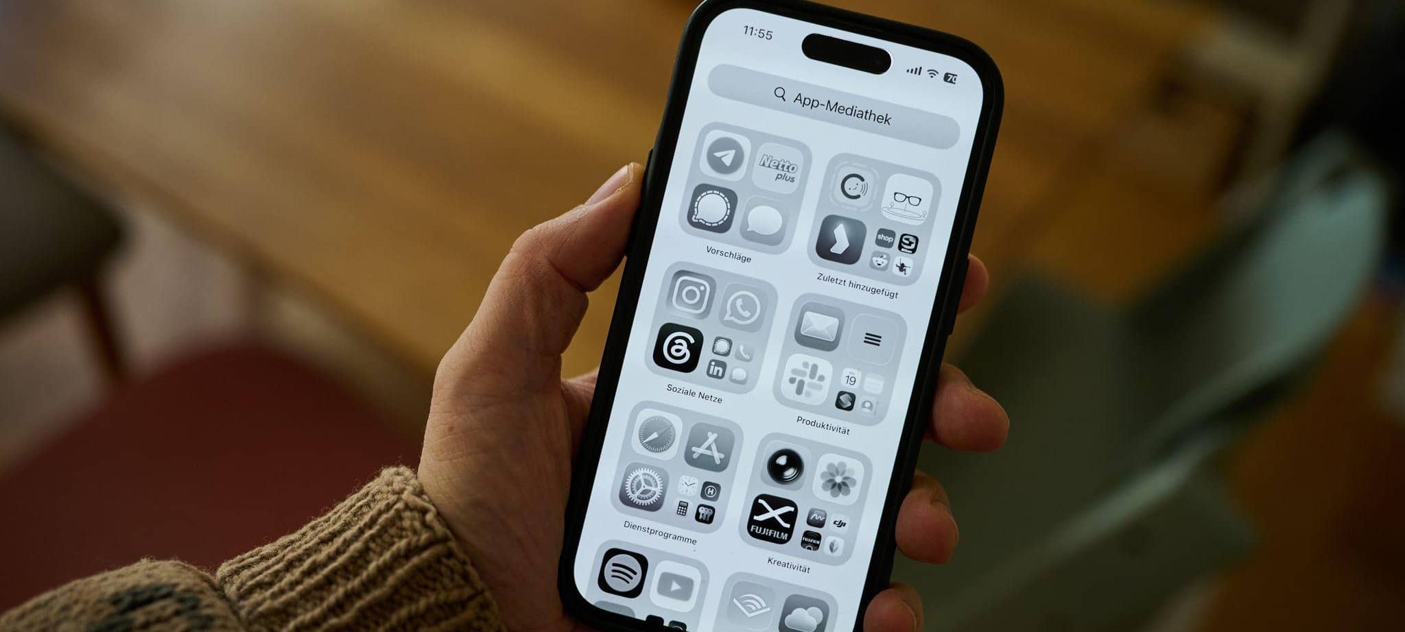 Ein Mann hält ein iPhone mit schwarz-weißem Display in der Hand